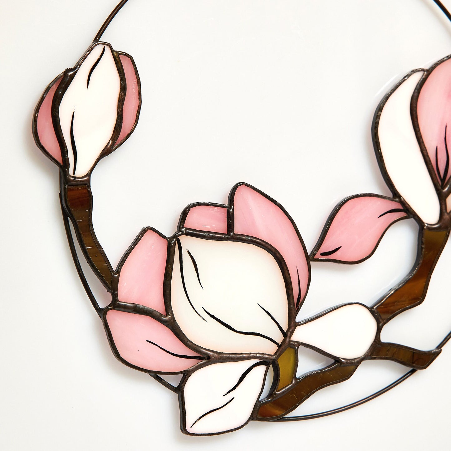 A close up photo of stained glass magnolia suncatcher