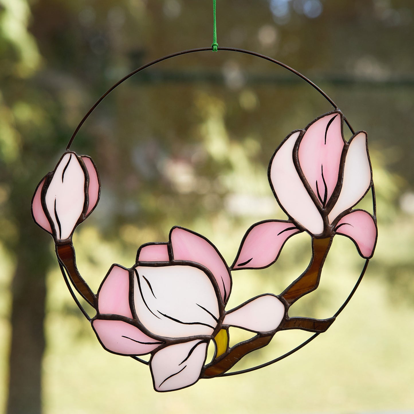 Stained glass magnolia suncatcher hanging in the window