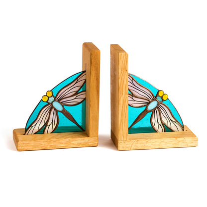 A pair of stained glass bookends with dragonfly motifs, set on wooden bases.