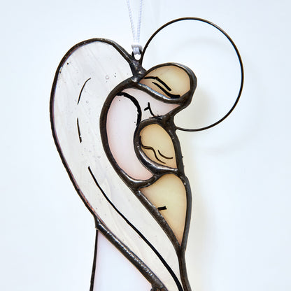 A hand crafted stained glass figurine of a grieving angel, with multicolored panels and a circular frame at the top, soldered together using the Tiffany technique.